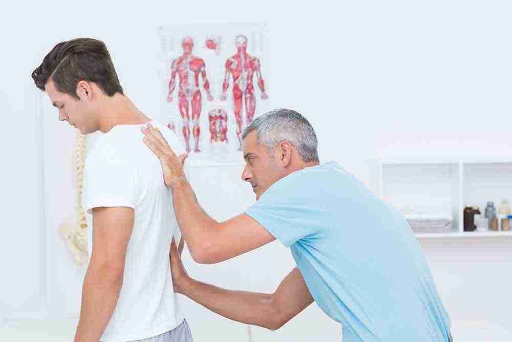 Osteopath assessing a patient's back